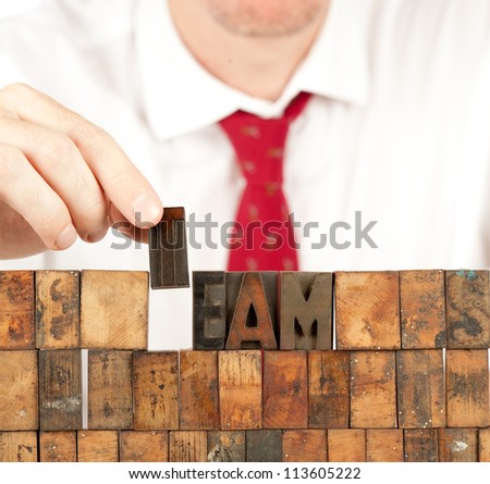 businessman building team word in letterpress on white background