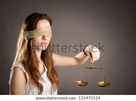 woman with covered eyes holding a justice scale