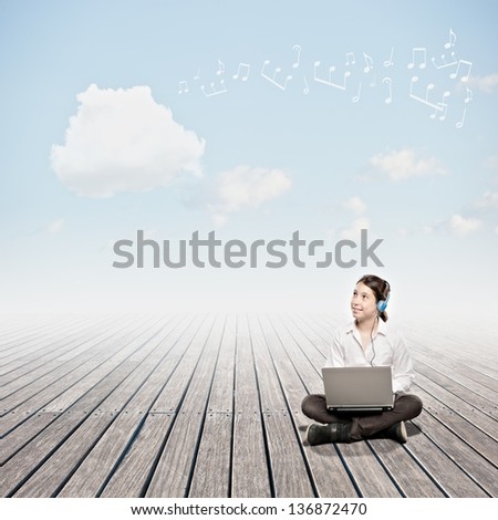 girl holding a laptop and looking to a cloud. Cloud computing concept.