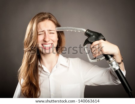 young woman shooting herself with a fuel pump nozzle