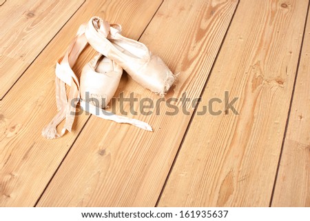 pair of old ballet shoes on wood floor
