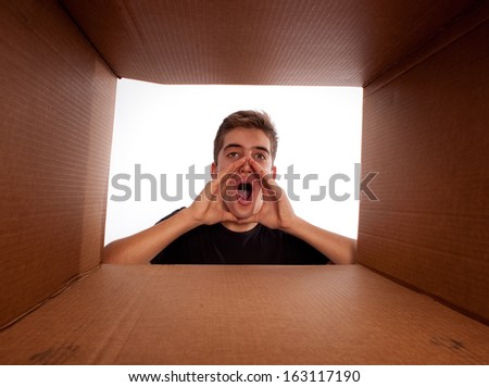 young man screaming inside a cardboard box