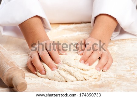 young chef working the dough with hands