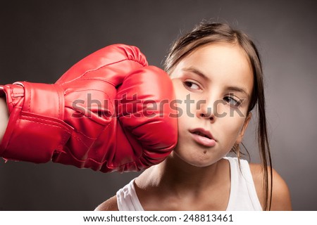 little girl and red boxing globe  hitting her face