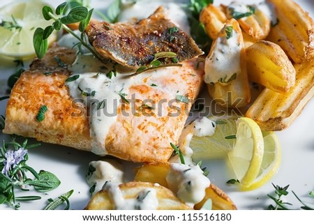 Grilled Atlantic salmon with herb sauce and baked potatoes. Delicious healthy eating.