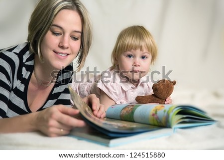 Mother and daughter looking at children\'s book