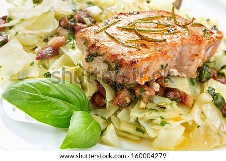 Pork chop with basil pesto, cabbage and bacon