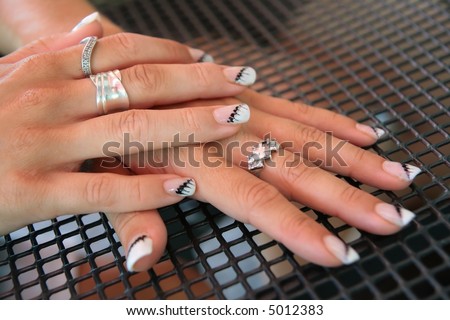 Beauty women hands with rings and varnished fingernails