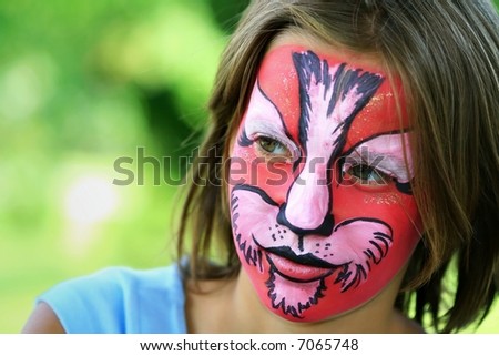 Young girl with face painted like a tiger