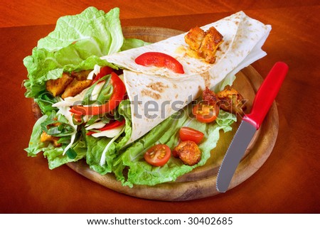 Healthy summer meal, grilled chicken and vegetables wrapped in a whole wheat tortilla