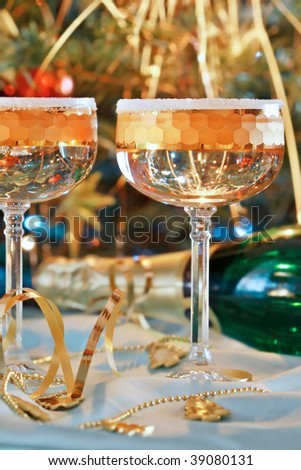 Fluted champagne glasses and ribbons on gold background