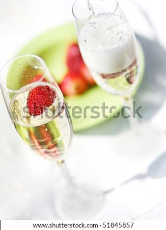 Champagne been poured in a flute with strawberry