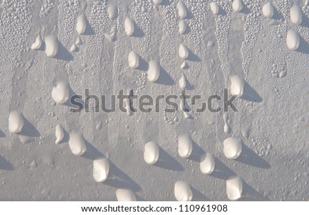 The drops of water on the white painted surface