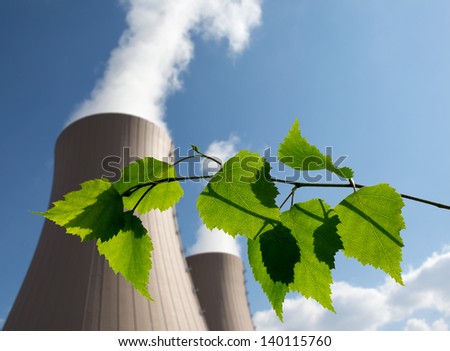 Green branch against nuclear power plant Conceptual image