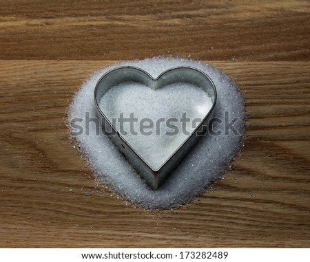 Heart shape cookie mold on the wood and sugar