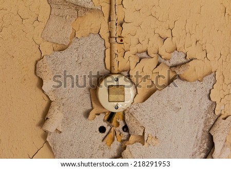 Old electrical switch and cable on a decrepit wall