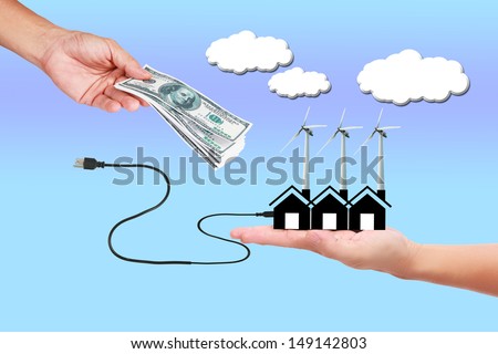 Image of wind turbine generating electricity with money in hand   on sky background.