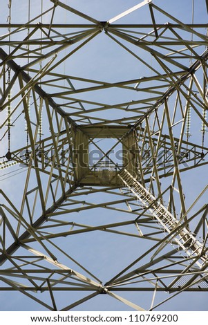 Low angle view of power pylon showing electrical distribution through energy cables