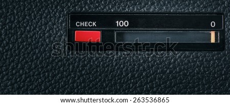 Close up of red check button on old retro technology equipment and scale with the numbers 0 and 100. Can be used as a conceptual image of classic old technology, testing or market research.