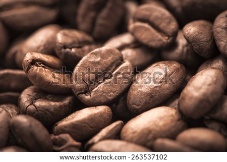 Closeup of dark roasted coffee beans. Food and drink backdrop showing aromatic and beautiful coffee beans. Can be used as a conceptual image for breakfast time or food and beverage.