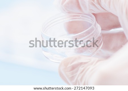 Hand of scientist working with fluids in lab. Conceptual image of clinical testing, scientific analysis and health science.