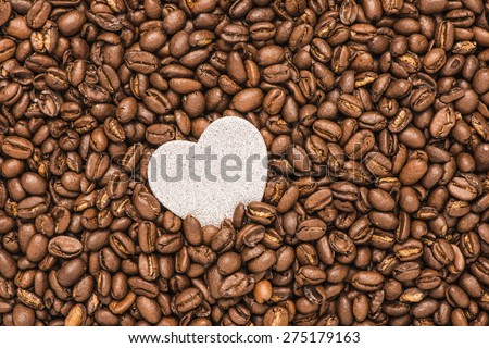 background of roasted coffe beans and a heart with copy space. Conceptual image of the love of coffee and great taste.