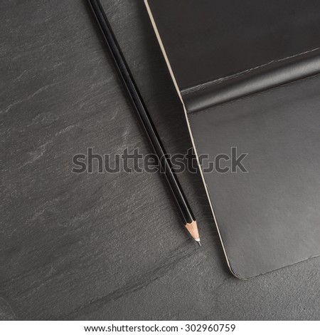 Pencil and black notebook. Conceptual image of office work, communication or writing.