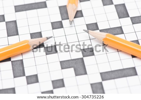 Closeup of crossword puzzle and three pens. Conceptual image of problem solving, finding solutions and intelligence.