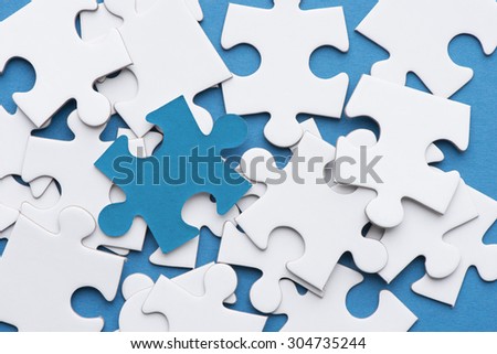Blue puzzle piece on white pieces. Conceptual image of connection, solution and business strategy.
