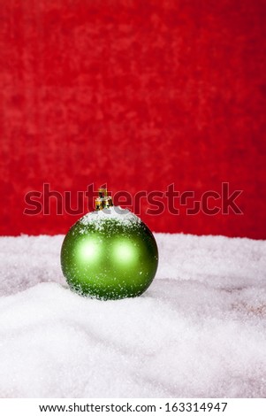 green Christmas ball in the snow