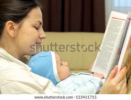 Young mother reading a book together with her baby
