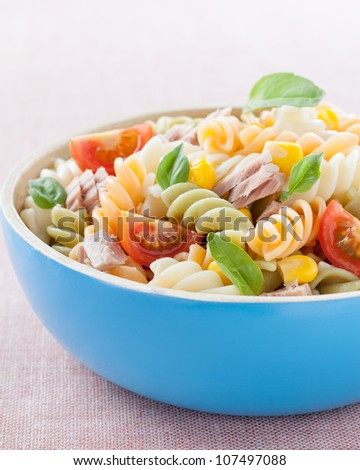 bowl of pasta salad with tuna, tomatoes, sweet corn and basil