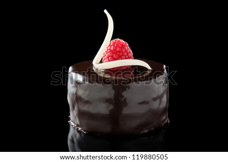 chocolate cake decorated with raspberries isolated on black