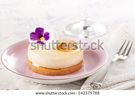 Fancy individual white chocolate cake on romantic table decorated with a flower