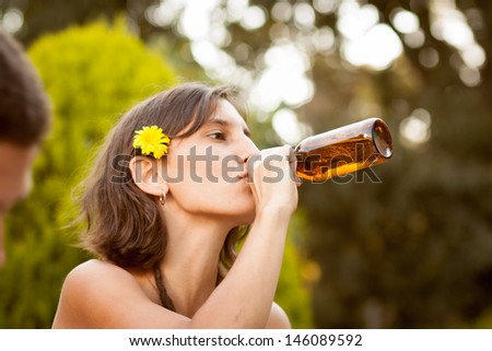 Beautiful young woman drinking beer in a terrace