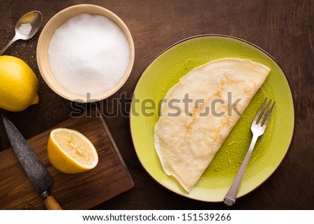 Lemon and sugar crepe on wooden table overview