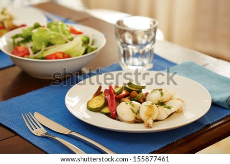 Grilled cuttlefish and vegetables in a table