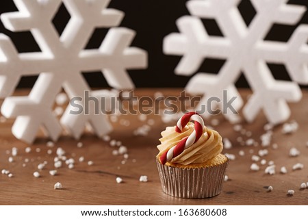 Candy bar cupcake on white snow flakes Christmas background