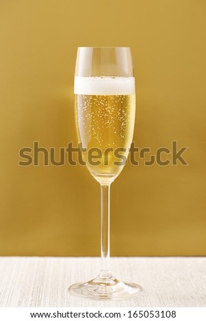 Cup of champagne on golden background sparkling wine