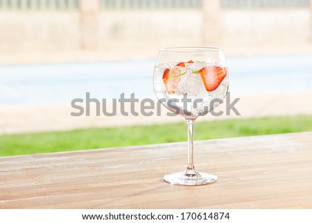 Strawberry gin and tonic cocktail on poolside bar