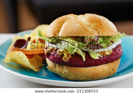 Beetroot burger on white bread with chips
