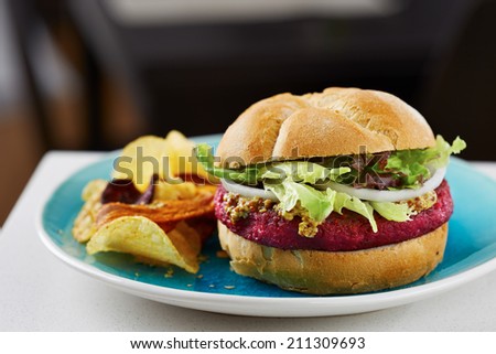 Beetroot burger on white bread with chips