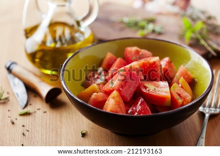 Bowl of raw tomato salad with olive oil and herbs