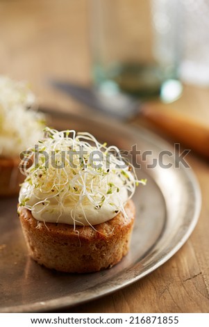 Individual carrot cake with cheese cream and sprouts