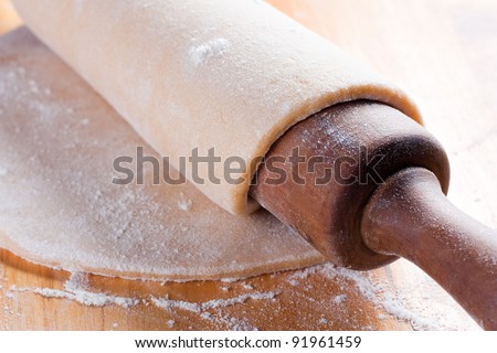 stretched dough with a rolling pin and flour