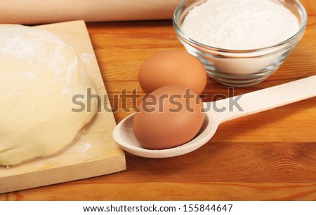Bread cooking. Baking. Eggs, dough, flour on wooden board