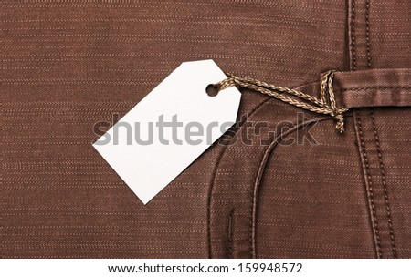 Blank paper label tag on brown jeans