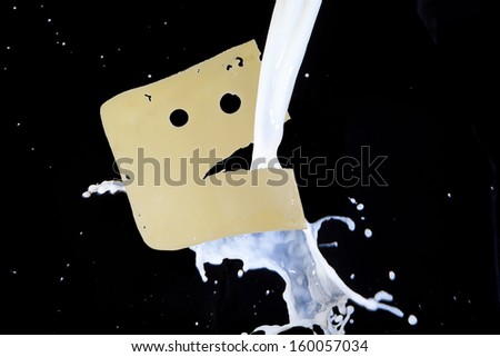 milk down on the piece of cheese shaped face with eyes and mouth