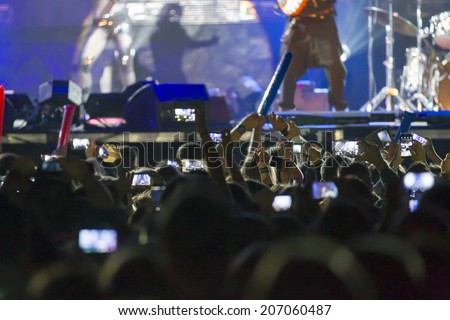 people recording a concert with mobile phones
