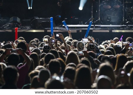 people recording a concert with mobile phones